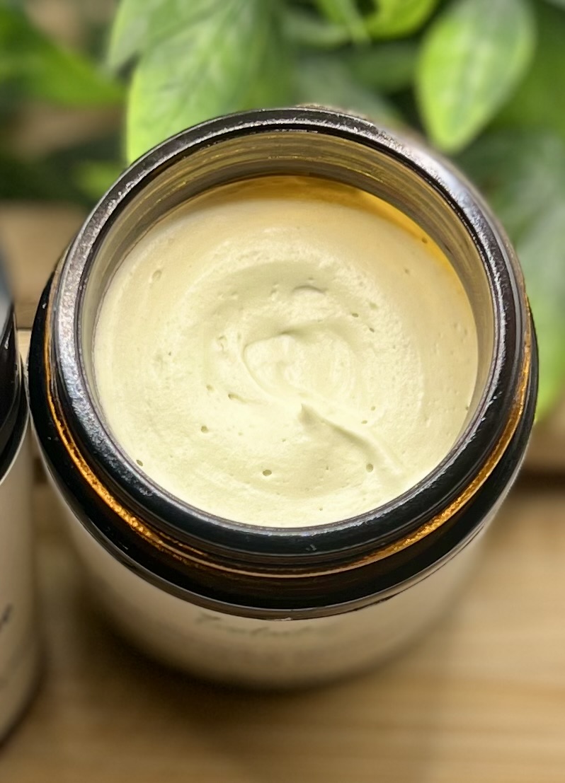 Close up overhead view of whipped tallow night moisturizer pale green gold cream texture Everlasting Organics
