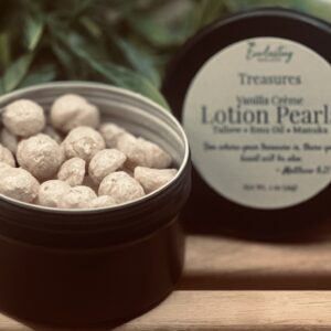 Open black matte tin of Everlasting Organics Solid Lotion Pearls with labeled lid showing Treasures collection, handcrafted with tallow, emu oil and manuka
