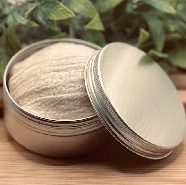 Body Blessings Solid Lotion Bar wrapped in muslin cloth inside an open tin container